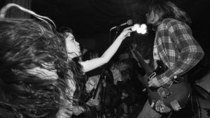 Live rock band performance in black and white.