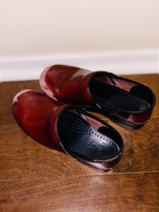 Red leather shoes on wooden floor.
