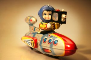 Vintage toy astronaut on colorful rocket.