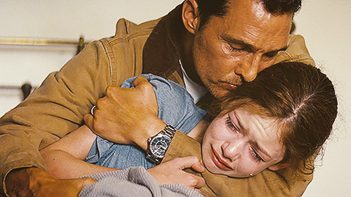 Man comforting a crying young girl.