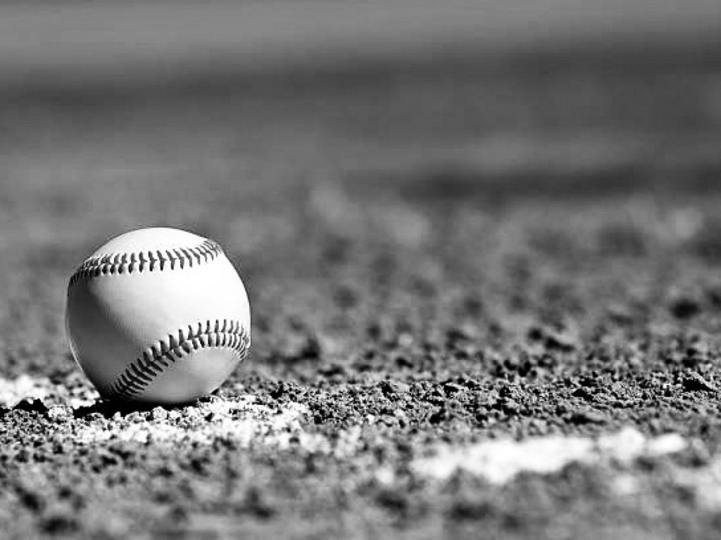 Baseball on a dirt field.