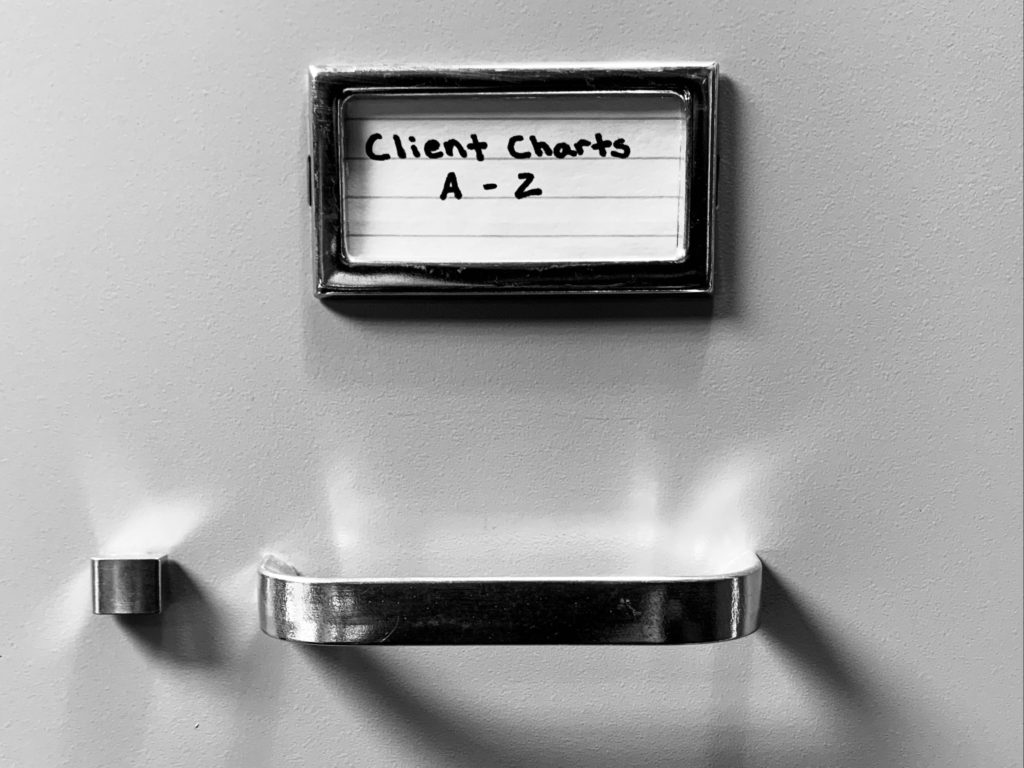 File cabinet labeled "Client Charts A-2.